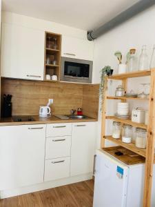 a kitchen with white cabinets and a microwave at Cozy studio on the roof, next to Incheba Expo in Bratislava