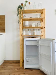 a kitchen with an open refrigerator and shelves at Cozy studio on the roof, next to Incheba Expo in Bratislava +6 photos