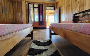 two beds in a room with wooden walls at Dimmaliz Homestay by StayApart in Pedong