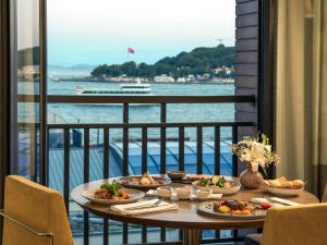 stół z dwoma talerzami jedzenia na balkonie w obiekcie Novotel Istanbul Bosphorus Hotel w Stambule