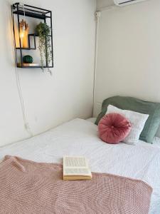 a book sitting on top of a bed with a mirror at Cozy studio on the roof, next to Incheba Expo in Bratislava