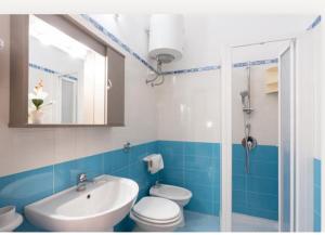 a blue and white bathroom with a toilet and a sink at Villa Dolce Vita rooms in Castelluzzo