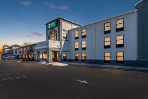 a large white building with a clock on top of it at Quality Inn & Suites Matthews in Matthews