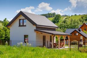 Casa blanca con techo marrón en Domek Jaśkowy w Tyliczu en Tylicz