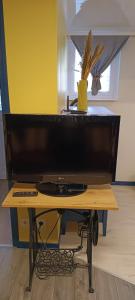 un gran monitor de ordenador en una mesa de madera en Studio à louer, en Clohars-Carnoët