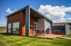 Casa pequeña con terraza y mesa en Einishus Cottages, en Laugar