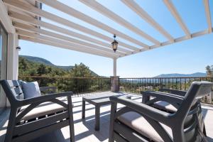 d'une terrasse avec 2 chaises et une table sur un balcon. dans l'établissement Olive Hills Villa - Family-Friendly Luxury Villa Uzumlu Fethiye by Sunworld Villas, à Fethiye