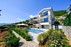 une maison avec une piscine et un jardin dans l'établissement Olive Hills Villa - Family-Friendly Luxury Villa Uzumlu Fethiye by Sunworld Villas, à Fethiye
