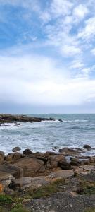 una playa con rocas y el océano en un día nublado en Studio à louer, en Clohars-Carnoët