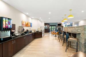 a kitchen and dining room with a bar and chairs at Comfort Inn & Suites in Tunkhannock