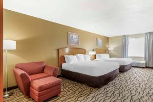 una habitación de hotel con 2 camas y una silla en Comfort Inn & Suites Chesapeake - Portsmouth, en Chesapeake