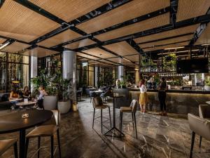 um restaurante com pessoas sentadas em mesas e um bar em Novotel Brisbane South Bank em Brisbane