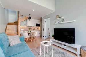 sala de estar con sofá azul y TV en Old Town apartment en Haapsalu