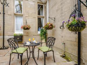 a patio with a table and chairs and flowers at 1 Bed in Langholm 83343 in Langholm