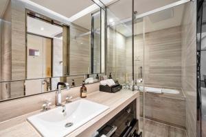 bagno con lavandino e doccia di Kempinski The One Suites Hotel Shanghai Downtown a Shanghai