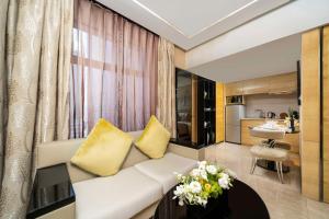 uma sala de estar com um sofá branco e almofadas amarelas em Kempinski The One Suites Hotel Shanghai Downtown em Xangai