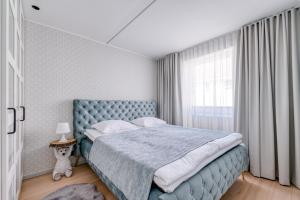 Un dormitorio con una cama azul y una ventana en Old Town apartment en Haapsalu