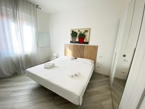 - une chambre avec un lit blanc et des serviettes dans l'établissement Palazzo Elios, à Parme