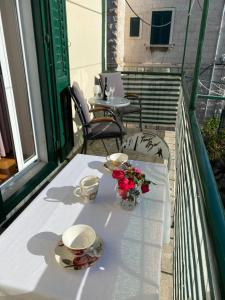 una mesa con 2 tazas y flores en el balcón en Apartment Mario, en Split