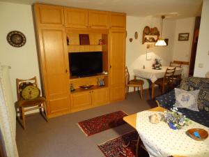 ein Wohnzimmer mit einem Sofa, einem TV und einem Tisch in der Unterkunft Haus Buchenwald in Ramsau bei Berchtesgaden