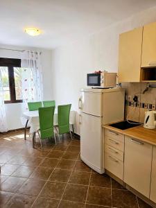 a kitchen with a refrigerator and a table with green chairs at Villa Vi apartmen in a villa with a swimming pool in Bar +47 photos