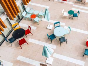 una vista aérea de una cafetería con mesas y sillas en greet Hotel La Rochelle Centre, en La Rochelle
