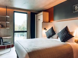 Un dormitorio con una cama grande y una ventana en greet Hotel La Rochelle Centre, en La Rochelle