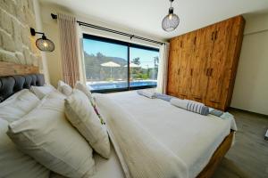 a large bed in a room with a large window at Oleander Hills Villa - Family-Friendly Luxury Villa Uzumlu Fethiye by Sunworld Villas in Fethiye