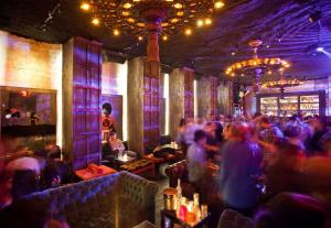 een menigte mensen in een bar met paarse lichten bij Dream Downtown, by Hyatt in New York