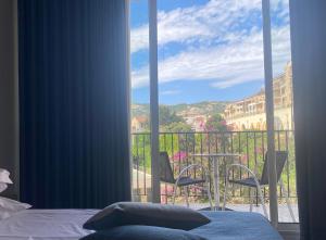 a bedroom with a view of a balcony with a table and chairs at Grand Hôtel De Calvi in Calvi