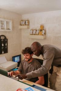 two men standing next to a man at a counter at Masseria della Piana in Villanova di Ostuni
