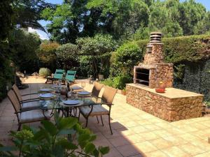 a patio with a table and a stone fireplace at Sagaró sea housegardenbarbacue8 paxsea view in Sant Feliu de Guixols