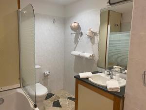 a bathroom with a shower toilet and a sink at Grand Hôtel De Calvi in Calvi