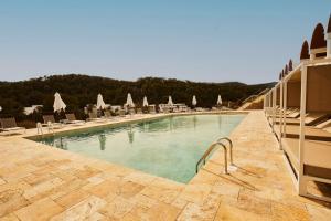 uma grande piscina com espreguiçadeiras e guarda-sóis em Cala San Miguel Hotel Ibiza, Curio Collection by Hilton, Adults only em Puerto de San Miguel