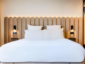 a bedroom with a large white bed with two pillows at TRIBE Milano Malpensa in Vizzola Ticino