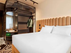 a bedroom with a large white bed and a closet at TRIBE Milano Malpensa in Vizzola Ticino