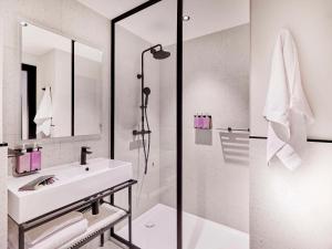 a white bathroom with a sink and a shower at TRIBE Milano Malpensa in Vizzola Ticino