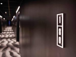 a wall with an exit sign in a hallway at TRIBE Milano Malpensa in Vizzola Ticino