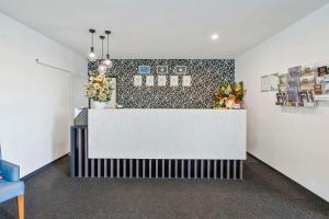 um lobby com um balcão branco com flores na parede em Quality Resort Parkhurst em Rockhampton