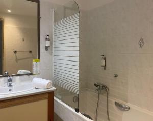 a bathroom with a glass shower and a sink at Grand Hôtel De Calvi in Calvi