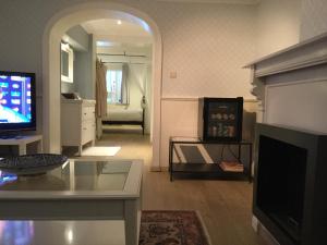 a living room with a television and a fireplace at B&B Wellness Yoake in Ypres