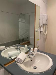 a bathroom with a white sink and a mirror at Grand Hôtel De Calvi in Calvi