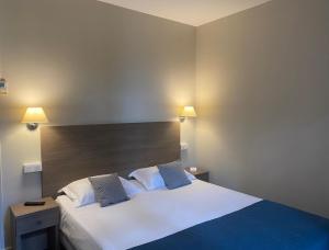a bedroom with a large white bed with two pillows at Grand Hôtel De Calvi in Calvi
