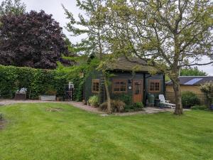 een klein groen huis in een tuin bij Captivating 1-Bed Log Cabin in Shrewsbury in Shrewsbury