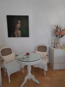 una mesa y dos sillas en una habitación con una pintura en Espaco Edla, en Sintra