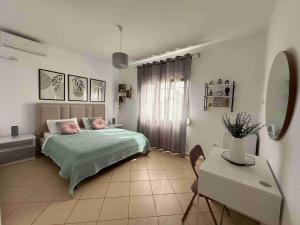 een slaapkamer met een bed, een tafel en een spiegel bij DreamAdes House in Dhërmi