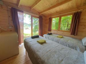 1 dormitorio con 2 camas en una cabaña de madera en Agriturismo Fattoria Ca Di Sole, en San Benedetto Val di Sambro