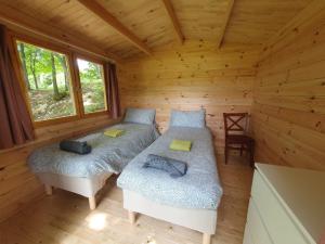 sypialnia z 2 łóżkami w drewnianym domku w obiekcie Agriturismo Fattoria Ca Di Sole w mieście San Benedetto Val di Sambro