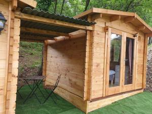 a wooden dog house with a window and a chair at Agriturismo Fattoria Ca Di Sole in San Benedetto Val di Sambro