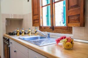 una encimera con fregadero y un jarrón de flores en Ideal Property Mallorca - Son Paulo, en Búger 31 fotos más